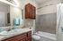 Chic bathroom featuring a sleek vanity with marble like countertop, polished fixtures, and modern tile accents.