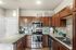 Stylish kitchen featuring dark wood cabinets, stainless steel appliances, and a sleek countertop with modern lighting.