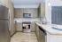 Modern kitchen with sleek wooden cabinets, stainless steel appliances, and a spacious layout.