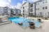 Elegant apartment complex with a pristine swimming pool and chic outdoor lounge area.