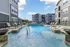 Inviting outdoor pool area surrounded by modern apartment buildings and lounge chairs.