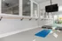Contemporary fitness studio with exercise mats, mirrored walls, barre, and equipment.
