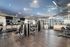 Modern fitness center with state-of-the-art gym equipment, sleek wooden floors, and mirrored walls for a premium workout experience.