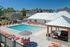Stunning outdoor pool area with vibrant red lounge chairs and sleek modern cabana, perfect for relaxation and entertainment.