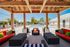 Chic outdoor pool area with vibrant lounge seating and shaded pergola, perfect for relaxing and entertaining.