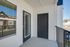 Charming apartment balcony featuring elegant black door and large windows, perfect for natural light and outdoor relaxation.