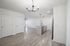 Modern open-concept kitchen and living space with sleek light fixtures and hardwood floors highlighting contemporary design.