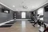 Modern fitness room with sleek wooden floors, equipped with exercise bikes, treadmills, and motivational wall art, perfect for an invigorating workout.