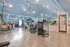 Bright and spacious fitness center with modern exercise equipment, stone accent walls, and a sky-themed ceiling.