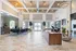 Modern lobby with elegant chandeliers, stylish seating, and marble flooring, highlighted by natural light and sophisticated decor.
