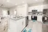 Modern open-concept kitchen with sleek granite countertops and stainless steel appliances, leading to a bright and airy living area.
