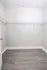 Spacious walk-in closet with sleek wire shelving and modern wood flooring.