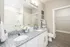 Elegant modern bathroom with granite double sink vanity, chic decor, and spacious walk-in closet.