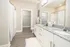 Elegant bathroom featuring a granite countertop, modern fixtures, and a spacious walk-in closet.