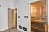 Luxurious sauna room with elegant wooden interiors and modern controls, offering a serene relaxation experience.