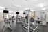 Modern gym facility equipped with state-of-the-art fitness machines and free weights, featuring ample natural light and sleek design.