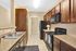 Elegant kitchen with rich wooden cabinets, modern appliances, and sleek countertops offering a perfect blend of style and functionality.