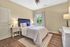 Inviting bedroom with a stylish upholstered bed, cozy bedding, natural light, and elegant decor.