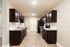 Elegant modern kitchen featuring dark wood cabinetry, sleek granite countertops, and stainless steel appliances, perfect for culinary enthusiasts.