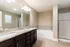 Luxurious modern bathroom featuring sleek double vanity, elegant marble countertops, and a relaxing soaking tub.