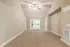 Bright and spacious living room with high ceilings, elegant neutral tones, and inviting carpet flooring, perfect for a cozy family gathering.