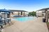 Inviting apartment complex with a sparkling swimming pool, surrounded by lounge chairs and cabanas, perfect for relaxation and social gatherings.