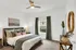 Bright and cozy model bedroom with plush carpet, stylish decor, and a large window for natural light.