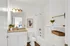 Bright and modern bathroom featuring elegant granite countertop, stylish fixtures, and chic decor, exuding upscale comfort.