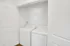Modern in-unit laundry with sleek white washer and dryer in a bright, spacious closet.