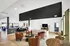 Spacious and inviting living room featuring modern decor, plush leather chairs, and abundant natural light, perfect for relaxing or entertaining.