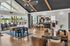 Contemporary open-plan apartment with a stylish kitchen, cozy lounge area, and expansive windows overlooking a sunlit patio with pool views.