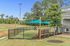 Inviting outdoor pet play area with shade sails and fenced section, surrounded by greenery, perfect for a relaxing day out with pets.