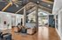 Elegant lobby with vaulted wood-beam ceiling, stone columns, and stylish seating area with modern decor.