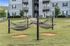 Inviting apartment complex with relaxing outdoor hammocks on a lush green lawn, perfect for enjoying tranquility and community living.