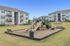 Inviting apartment complex with a charming playground, featuring slides and green open spaces, perfect for family living.
