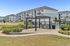 Charming apartment community with modern barbecue area, lush landscaping, and inviting outdoor seating near poolside.