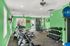 Vibrant fitness center with cardio machines, free weights, and bright green walls, perfect for energizing workouts.