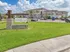 Inviting exterior shot of The Dakota luxury apartments in Victoria, TX, featuring modern architecture, a manicured lawn, and ample parking.