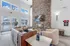 Elegant living space featuring a cozy stone fireplace, plush seating, and large windows overlooking a serene outdoor view.