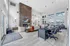 Elegant modern office space with rustic stone fireplace, plush seating, and ample natural light from large windows.