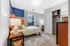 Cozy bedroom with a vibrant tapestry, bright window, and stylish decor, perfect for a peaceful retreat.