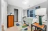 Bright bedroom with cozy bedding, vibrant geometric carpet, modern lamp, and ample closet space.