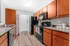 Modern kitchen with sleek countertops, stylish wooden cabinets, and black appliances, perfect for culinary enthusiasts seeking elegance and functionality.