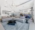 Contemporary open-concept living room featuring a chic gray sofa, stylish pendant lighting, and a modern geometric coffee table, perfect for relaxation and entertainment.