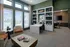 Elegant office space with modern shelving, cozy seating, and large windows offering ample natural light.