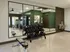 Modern fitness center with sleek gym equipment, mirrored walls, and elegant green accents for an energizing workout experience.