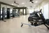 Modern fitness center featuring state-of-the-art exercise equipment, including treadmills, rowing machines, and strength training stations, all within a spacious, well-lit room.