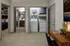 Modern apartment interior featuring an in-unit laundry area, stylish home office space, and view into a cozy bedroom and elegant bathroom.