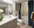 Elegant bathroom featuring sleek cabinetry, modern fixtures, and a luxurious bathtub with soft lighting.