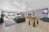 Inviting recreation room featuring a foosball table, cozy seating area, and bright windows with a lively atmosphere.